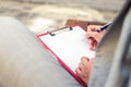 Closeup of a female hand writing on a blank planner with a pen. Royalty Free Stock Photo