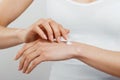 Closeup shot of woman hands holding cream and applying moisturizing hand cream. Beautiful female hands with cream. Royalty Free Stock Photo