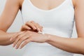 Closeup shot of woman hands holding cream and applying moisturizing hand cream. Beautiful female hands with cream. Royalty Free Stock Photo