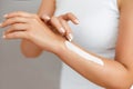 Closeup of female hands applying hand cream.Hand Skin Care. Women use body lotion on your arms. Beauty And Body Care Concept.