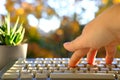 Closeup female hands of elderly woman typing text on computer keyboard in garden, concept of learning to use computer at any age, Royalty Free Stock Photo