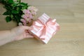Closeup female hands holding a box with gift, bouquet of white, pink roses, box with gift with satin ribbon, flowers for Royalty Free Stock Photo