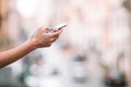 Closeup of female hands holding cellphone outdoors on the street. Woman using mobile smartphone. Royalty Free Stock Photo