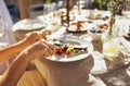 Closeup of female hands holding fork and knife. Young woman eating delicious meal outdoors Royalty Free Stock Photo