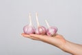 Closeup of female hands holding fresh whole garlic, spices and ripe vegetables on arm, flavory spicy ingredients