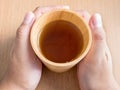 Closeup of female hands holding wood cup of Organic Jasmine Tea Royalty Free Stock Photo