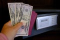 closeup female hands holds American dollars banknotes, personal documents, tourist puts money in hotel mini safe with electronic Royalty Free Stock Photo