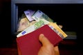 closeup female hands holds 50, 500 euro banknotes of european union, personal documents, tourist puts money in hotel safe with Royalty Free Stock Photo