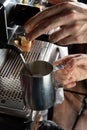 Closeup female hands are making coffee using professional metal machine in cafe Royalty Free Stock Photo