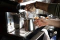 Closeup female hands are making coffee using professional metal machine in cafe Royalty Free Stock Photo