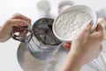 closeup of female hands sifting flour through sieve Royalty Free Stock Photo