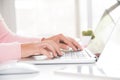 Closeup female hands typing on laptop keyboard. Woman working at home office