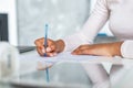 Closeup female hands during writing with pen on a paper