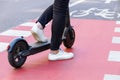 Young woman with colored dreadlocks riding electric scooter