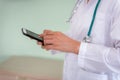 Closeup of female medical doctor is using smart phone Royalty Free Stock Photo