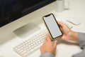 Closeup female office worker holding smartphone with empty screen sitting at her workplace Royalty Free Stock Photo