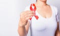 Closeup of female with red ribbon HIV AIDS on hand Royalty Free Stock Photo