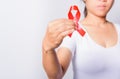 Closeup of female with red ribbon HIV AIDS on hand Royalty Free Stock Photo