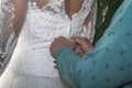 Closeup of a female's hands zipping up the bride's dress