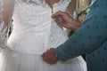 Closeup of a female's hands zipping up the bride's dress