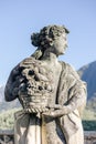 Closeup of female statue holding basket with fruits in park of Villa Balbianello