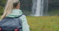 Closeup of female traveler back with backpack loking to Beautiful Seljalandsfoss waterfall Iceland Royalty Free Stock Photo