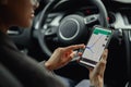 Closeup of female traveler using cell phone with gps navigation app on screen while sitting in car Royalty Free Stock Photo