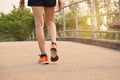 Closeup female walking with orange shoes on road in park for health concept Royalty Free Stock Photo