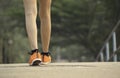 Closeup female walking with orange shoes on road in park for health concept Royalty Free Stock Photo