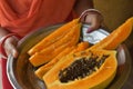 Closeup of female, woman hands showing, holding a steel plate with ripe fresh orange papaya Royalty Free Stock Photo