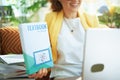 Female showing textbook in living room in sunny day Royalty Free Stock Photo