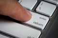 Closeup of finger on enter key in a keyboard. Royalty Free Stock Photo
