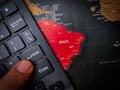 Closeup of a finger pressing "enter" on a black keyboard on top of the Brazil map - business concept Royalty Free Stock Photo