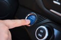 Closeup of a finger pushing the blue button of "Power on" in the car Royalty Free Stock Photo