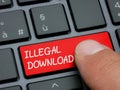 Closeup finger typing on illegal download key on computer keyboard Royalty Free Stock Photo