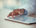 Closeup on fingers of doctor working on a digital tablet. Medical doctor using an online app on a wireless tablet Royalty Free Stock Photo