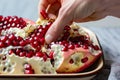 closeup of fingers pulling arils from a pomegranate section Royalty Free Stock Photo