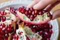 closeup of fingers pulling arils from a pomegranate section Royalty Free Stock Photo