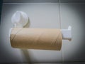 Closeup of finished toilet paper roll in bathroom. Empty roll on toilet paper holder with white wall background. Vintage, lowkey Royalty Free Stock Photo