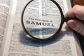 closeup of the first book of Samuel from Bible or Torah using a magnifying glass to enlarge print. Royalty Free Stock Photo