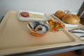 Closeup of fish in a bowl, next to a colorful salad and loaves of bread in a white tray Royalty Free Stock Photo