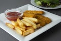 Closeup fish and chips with french fries - unhealthy food, grey backgrpound Royalty Free Stock Photo