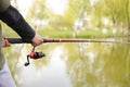 Closeup of fisherman`s hand holding rod with spinning Royalty Free Stock Photo