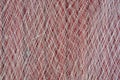 Closeup of fishing net hanging on a red wooden wall Royalty Free Stock Photo
