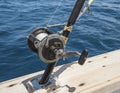 Closeup of fishing rod reel on side of boat Royalty Free Stock Photo