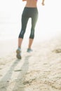 Closeup on fitness young woman running on beach Royalty Free Stock Photo