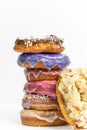 Closeup of five assorted donuts, each topped with a variety of sprinkles, fruits and syrups