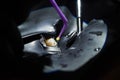 Closeup of fixing a tooth using a black rubber dam and dental instruments