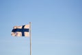 Closeup of the flag of Finland waving on a pole against a blue sky Royalty Free Stock Photo