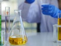 Closeup flask and measuring cylinders with scientist in background Royalty Free Stock Photo